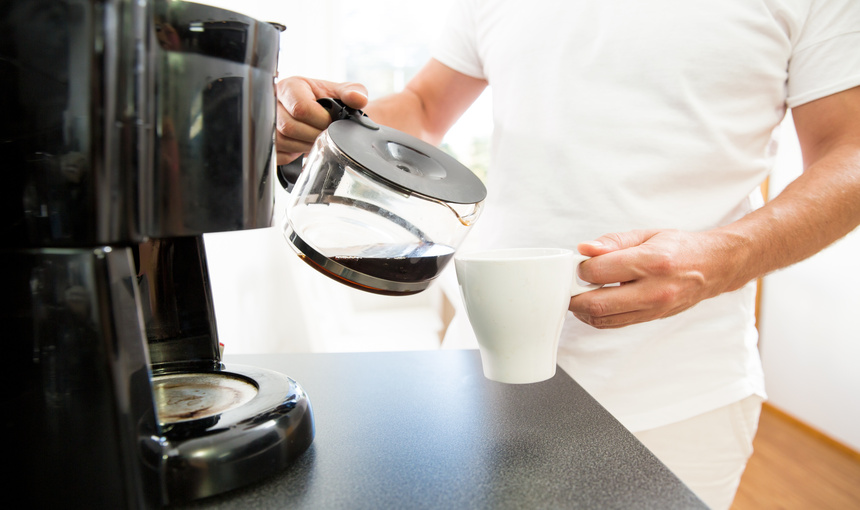 Man pouring fresh coffee into a cup.